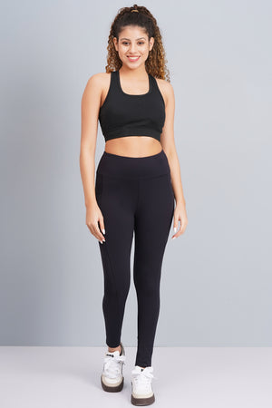 Woman wearing a black athletic outfit on a gray background