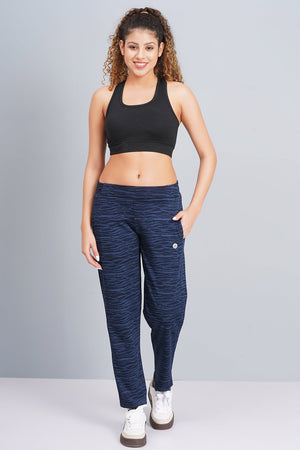 Woman wearing a black sports bra and blue leggings on a gray background