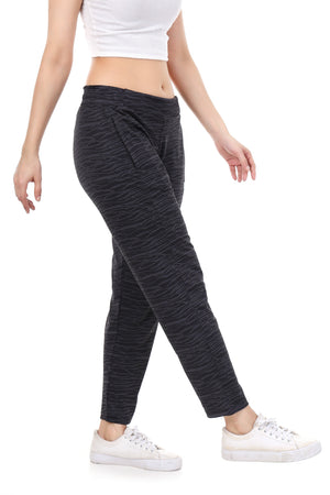 Person wearing dark gray jogger pants and white sneakers on a white background