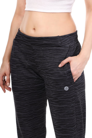 Black patterned pants worn by a person on a white background