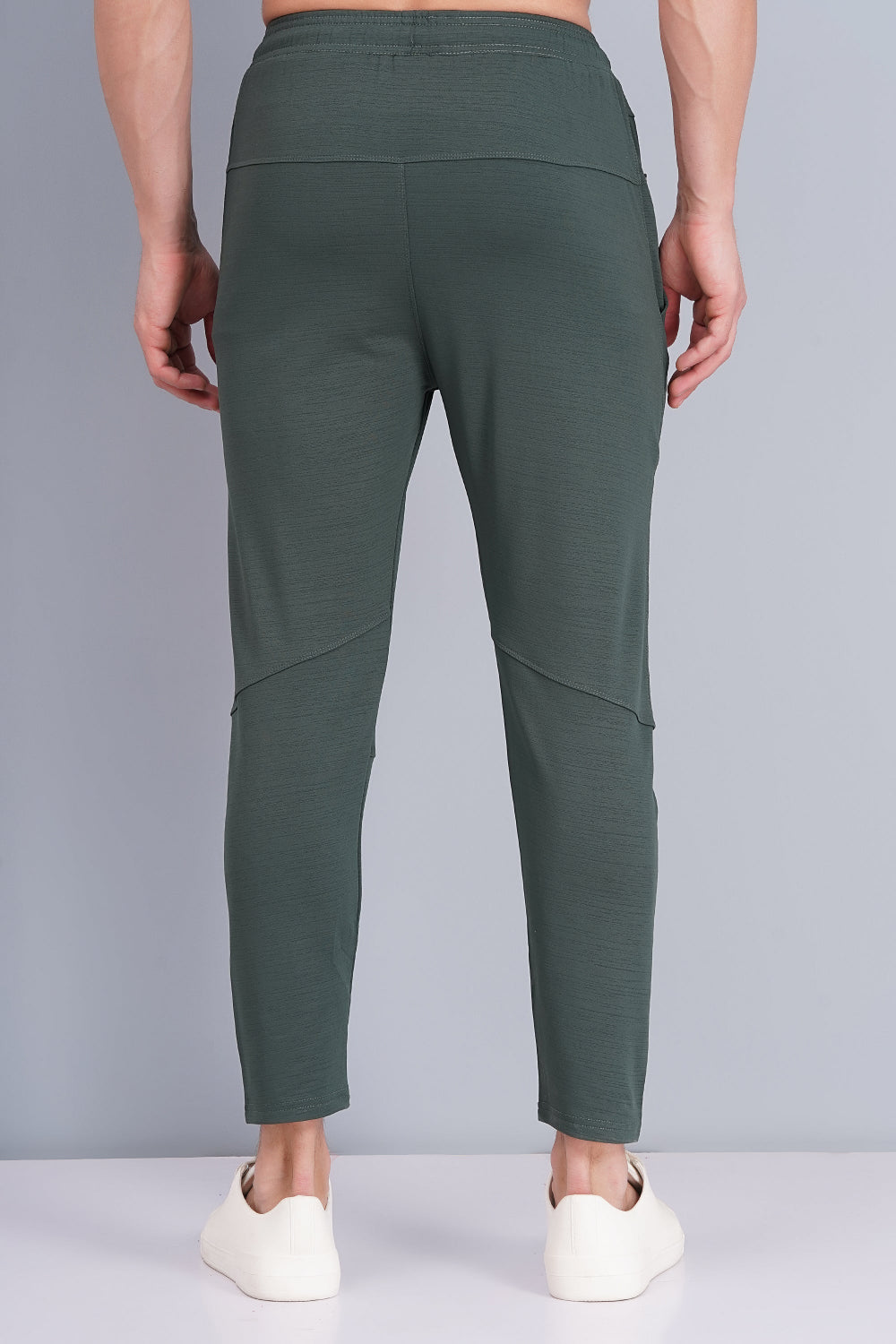 Green pants worn by a person on a gray background