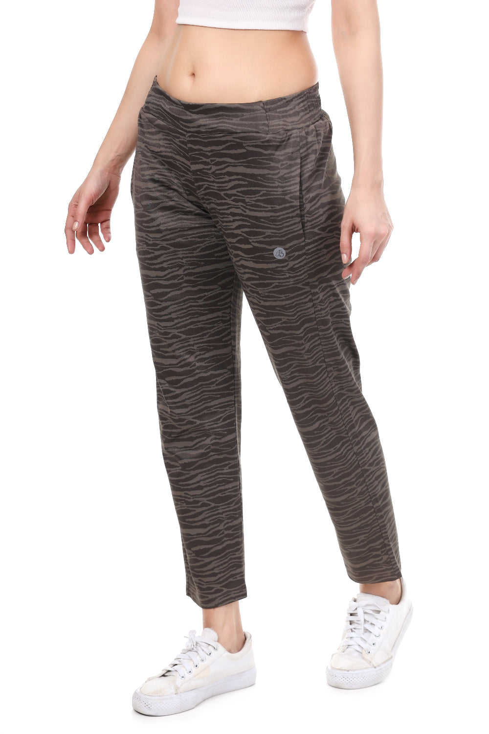 Person wearing patterned pants and white sneakers on a white background