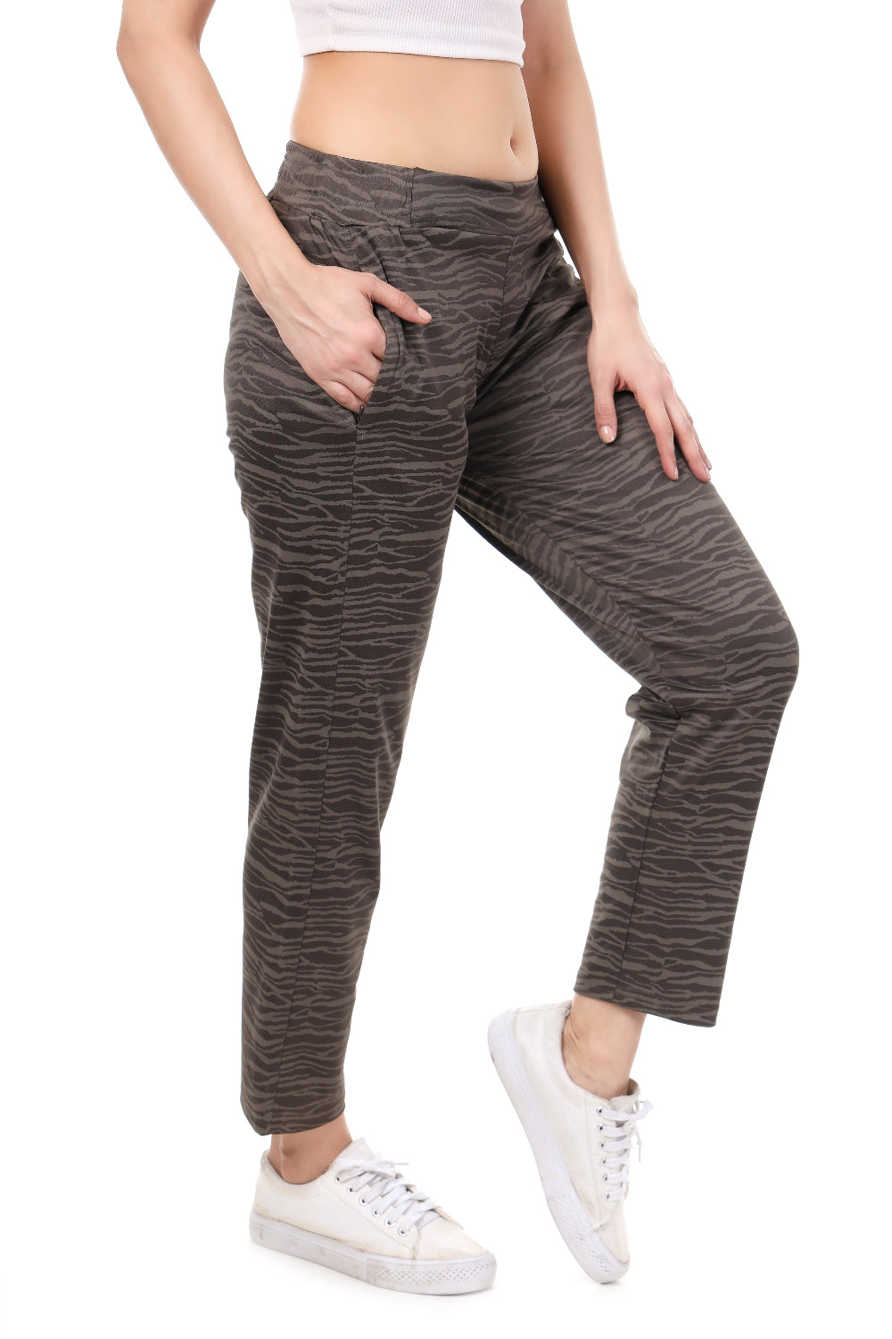 Person wearing brown marbled pants and white sneakers on a white background